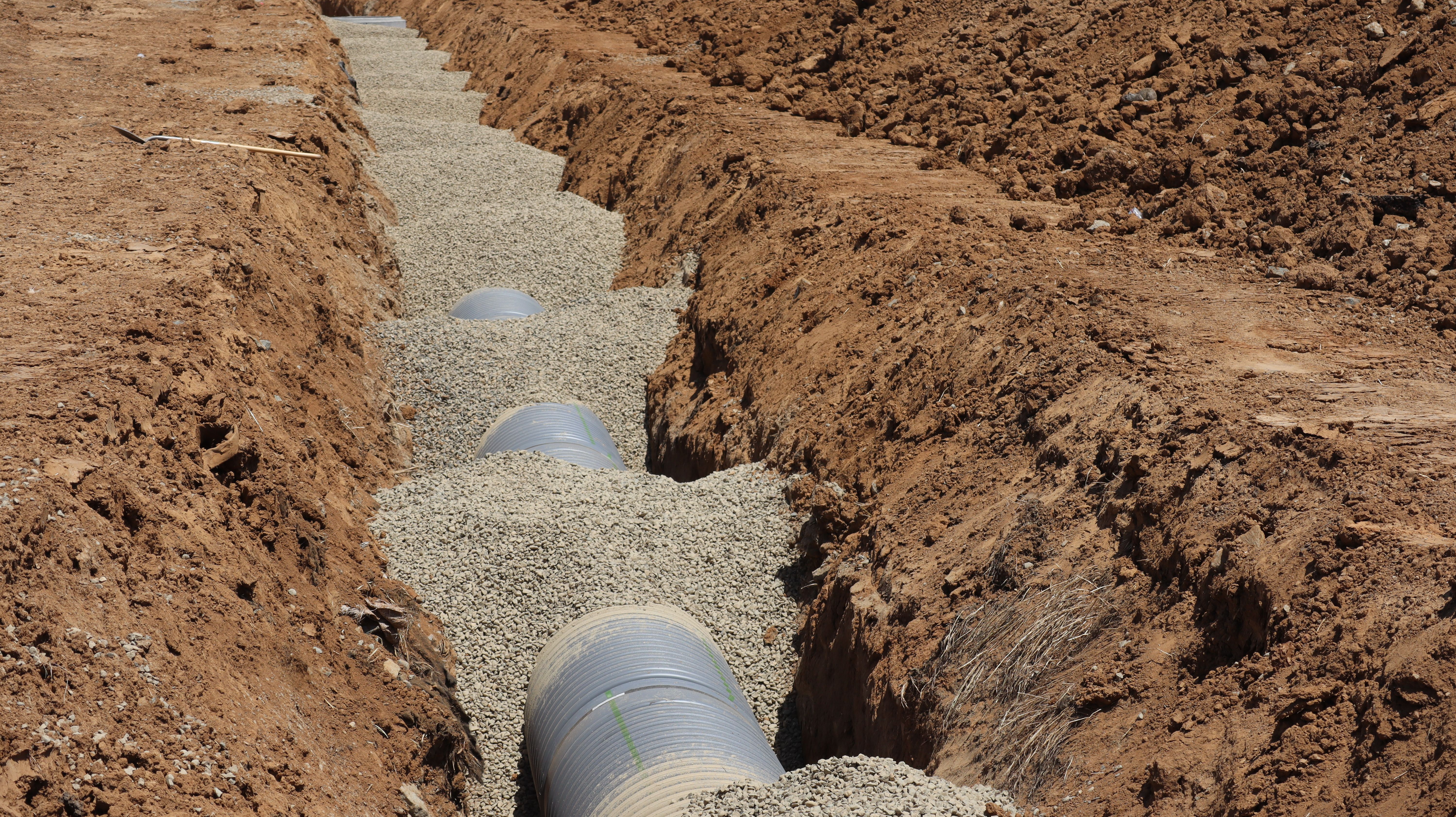 Drainage pipe installation in an excavation trench